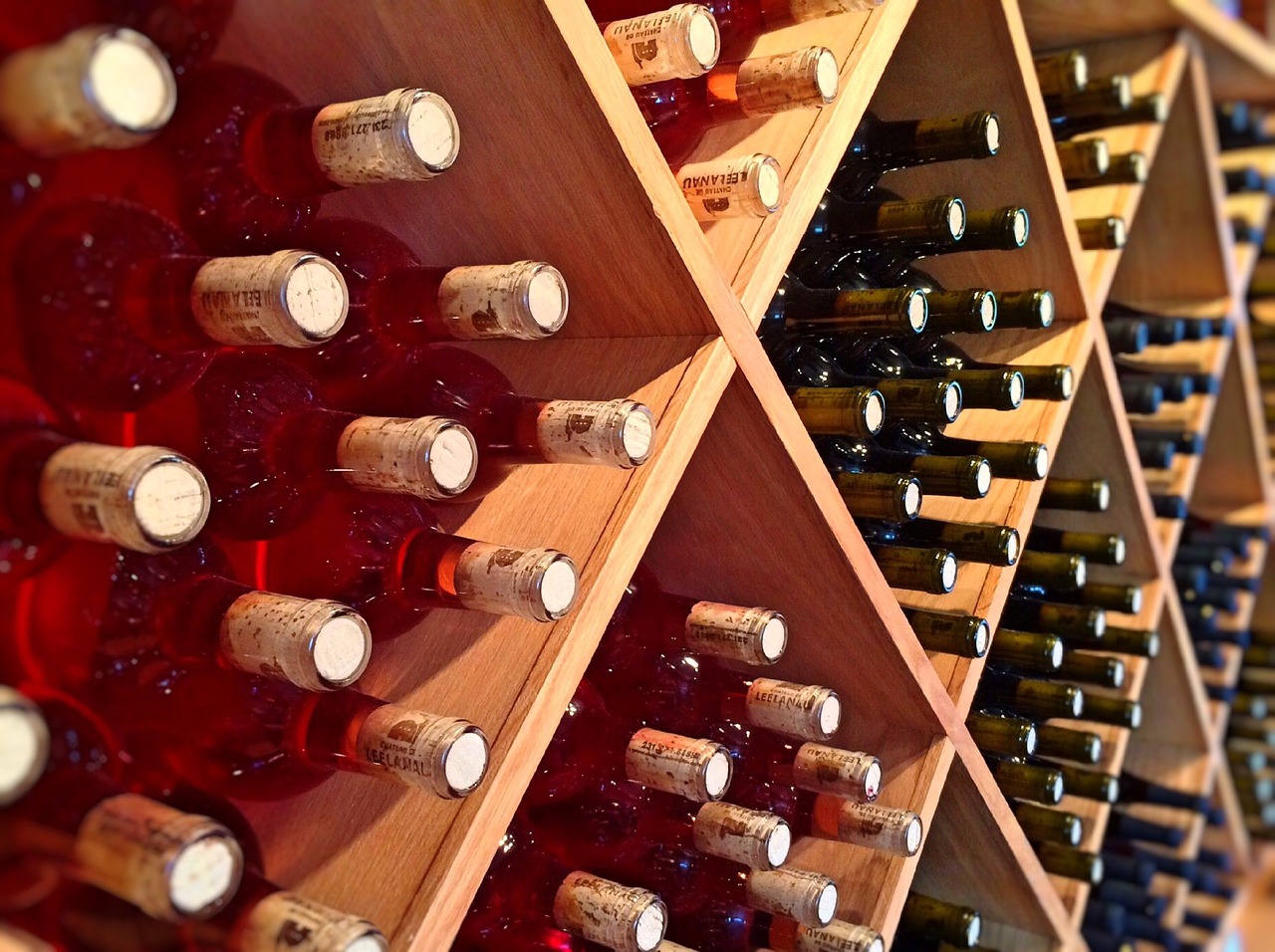 Wine bottles stored both standing upright and lying on their sides in a home rack